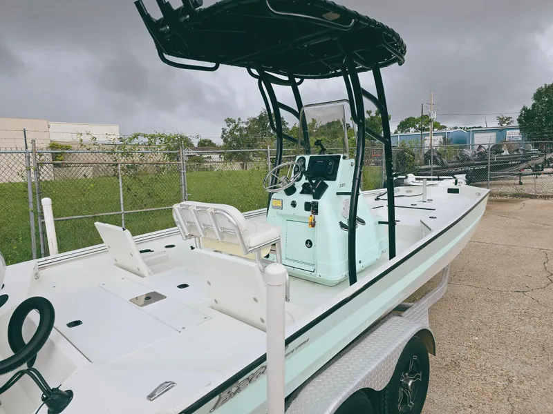 Slide: The Image of 2021 Excel Bay Pro boat on trailer, parked outdoors, overcast sky. - 7