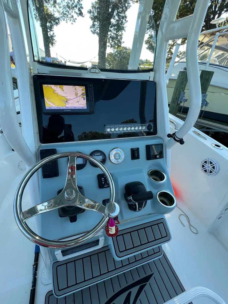 Slide: The Image of 2021 Tidewater 232 LXF boat dashboard with steering wheel and navigation display. - 9