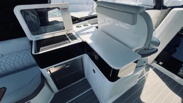 Slide: The Image of 2023 Sea Ray 370 Sundancer interior with modern kitchenette and seating area. - 11