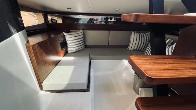 Slide: The Image of Interior of 2023 Sea Ray 370 Sundancer yacht with modern seating and wooden accents. - 24