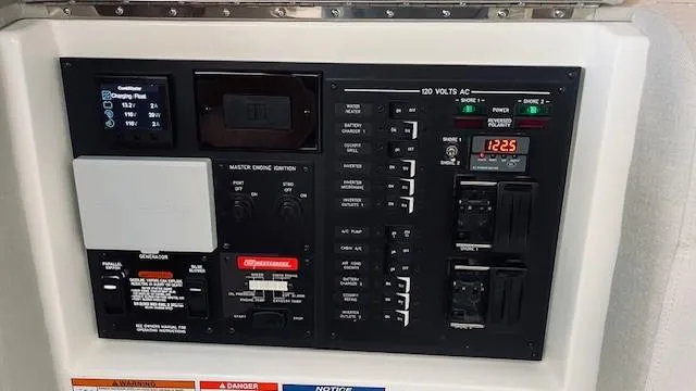 Slide: The Image of Control panel of 2023 Sea Ray 370 Sundancer boat, featuring various switches and displays. - 28