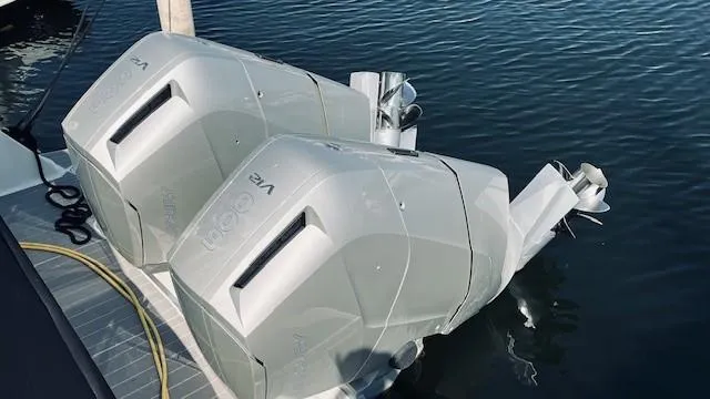 Slide: The Image of Twin outboard engines on 2023 Sea Ray 370 Sundancer, docked on calm water. - 29