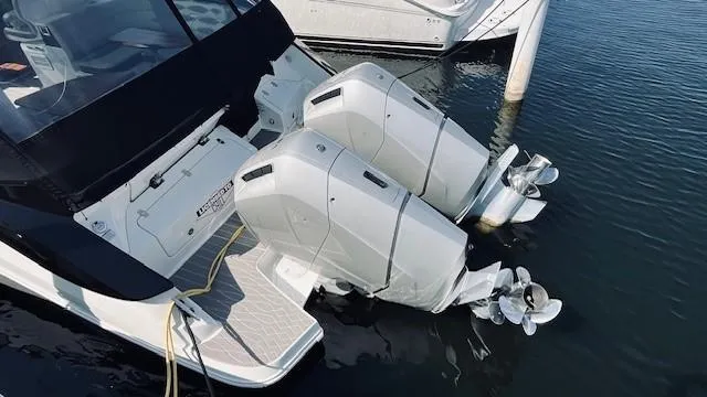 Slide: The Image of 2023 Sea Ray 370 Sundancer with dual outboard engines docked in water. - 31