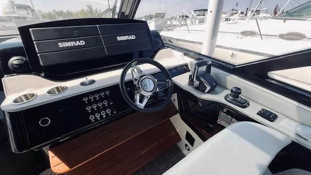 Slide: The Image of 2023 Sea Ray 370 Sundancer helm with Simrad electronics and modern controls. - 4