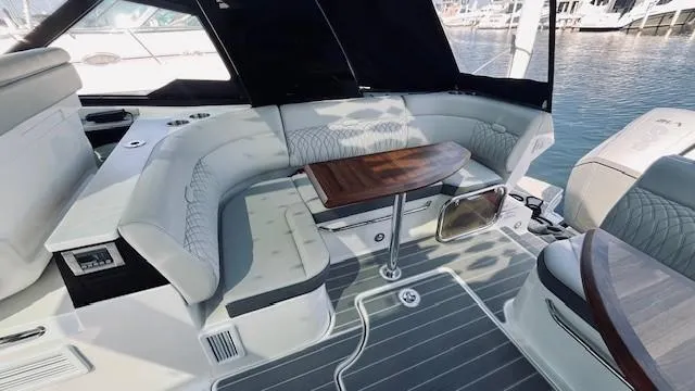 Slide: The Image of 2023 Sea Ray 370 Sundancer yacht interior with elegant seating and wooden table. - 7