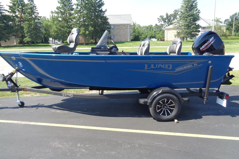 The Image of 2025 Lund 1650 Rebel XL SS boat on trailer, blue exterior, parked outdoors. - 0