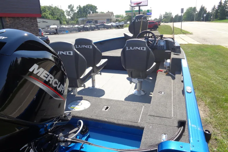 Slide: The Image of 2025 Lund 1650 Rebel XL SS boat with Mercury engine, parked outdoors. - 4