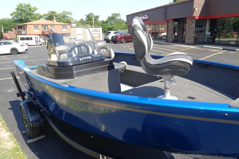 Slide: The Image of 2025 Lund 1650 Rebel XL SS boat in parking lot, featuring blue exterior and modern seating. - 6