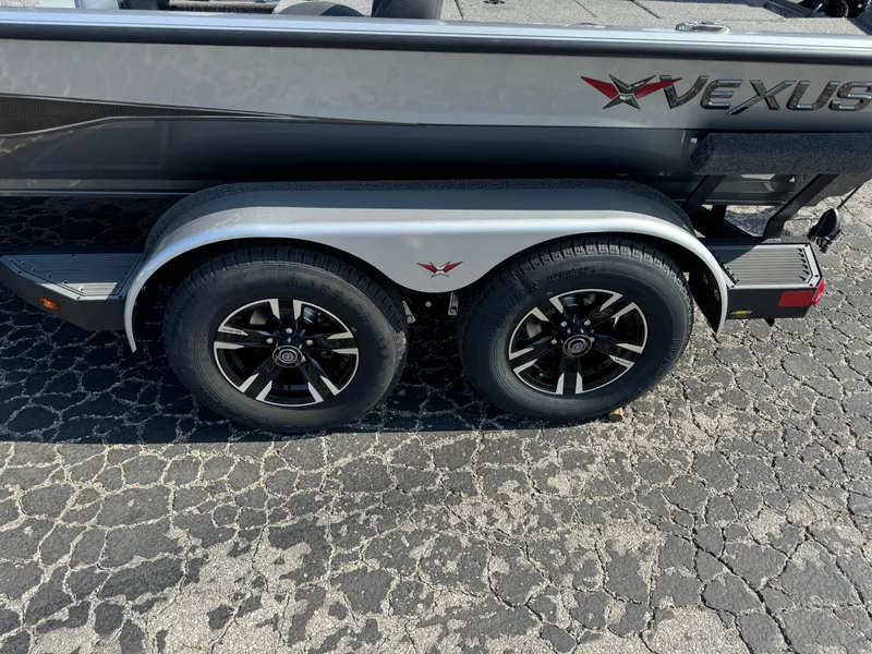 Slide: The Image of 2025 Vexus AVX1980 boat trailer with dual black alloy wheels on asphalt. - 5