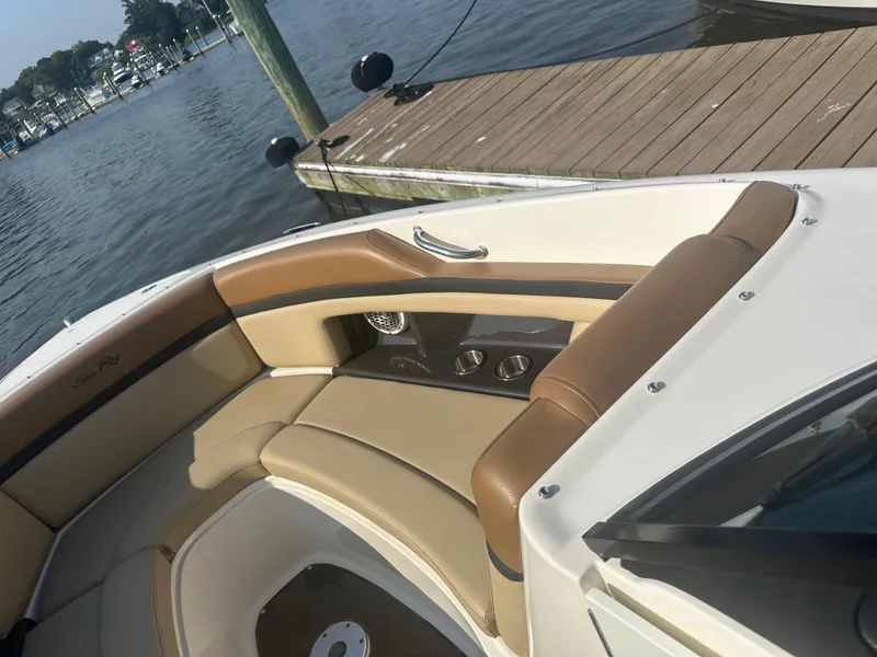 Slide: The Image of 2014 Sea Ray 270 SLX boat interior with tan seating by a dock. - 16