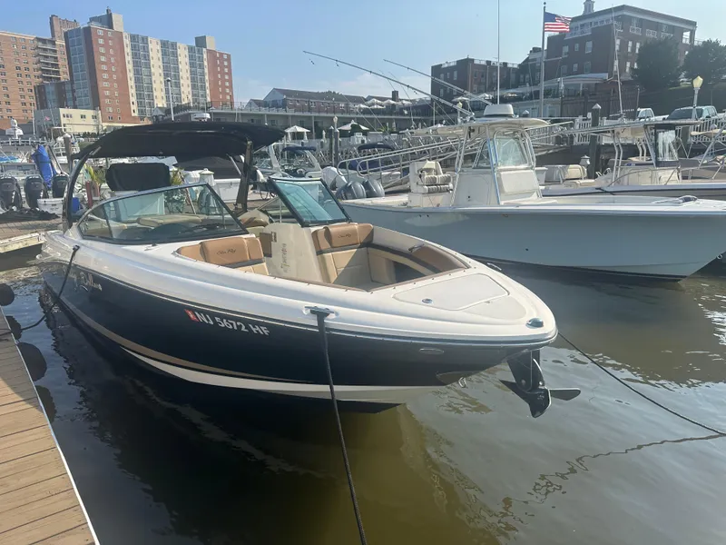 Slide: The Image of 2014 Sea Ray 270 SLX boat docked in a marina with cityscape background. - 2