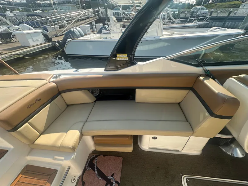Slide: The Image of 2014 Sea Ray 270 SLX boat interior with tan seating at marina. - 8