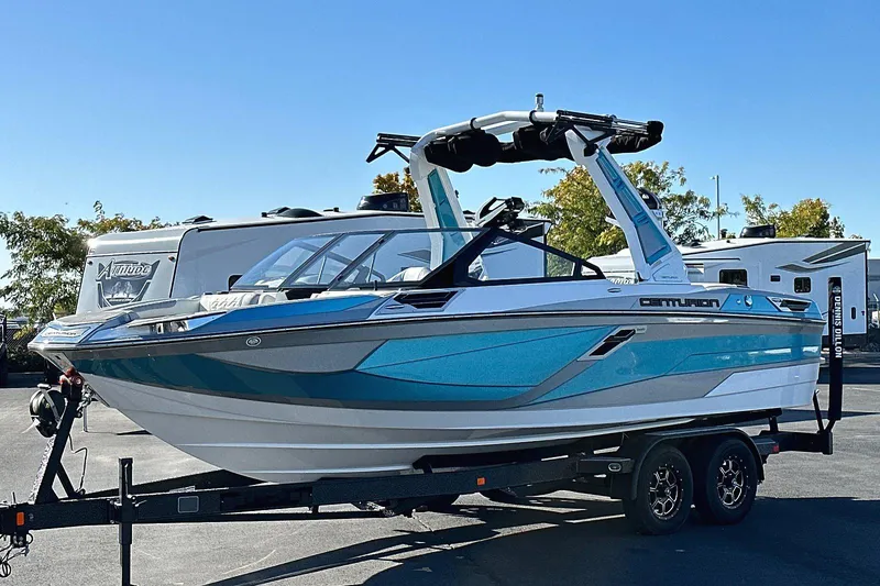 Slide: The Image of 2024 Centurion Ri230 boat on trailer, featuring sleek blue and white design. - 3