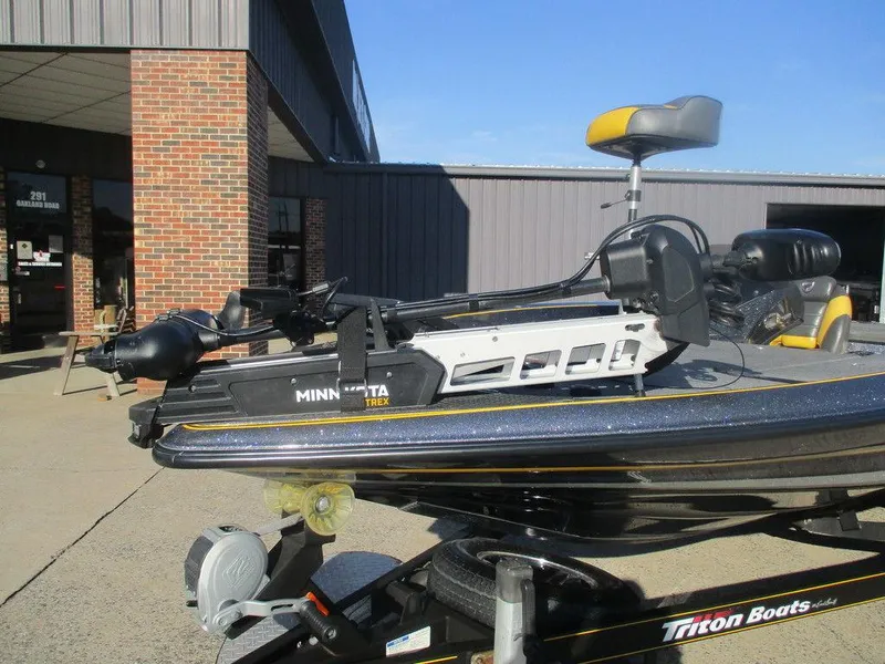 Slide: The Image of 2016 Triton 20 TRX boat with Minn Kota trolling motor, parked outside a building. - 3