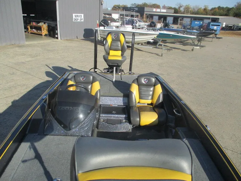 Slide: The Image of 2016 Triton 20 TRX boat with yellow and black seats in a marina setting. - 7