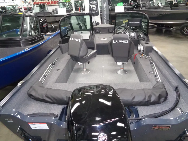 Slide: The Image of 2024 Lund 1650 Angler SS boat, red exterior, parked on trailer with Mercury engine. - 2