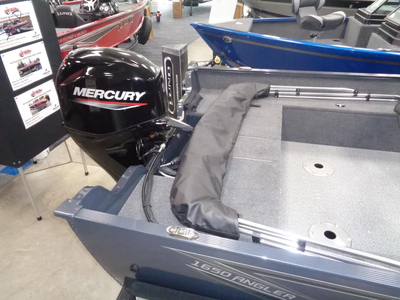 Slide: The Image of 2024 Lund 1650 Angler SS boat in vibrant red on a trailer, parked outdoors. - 3