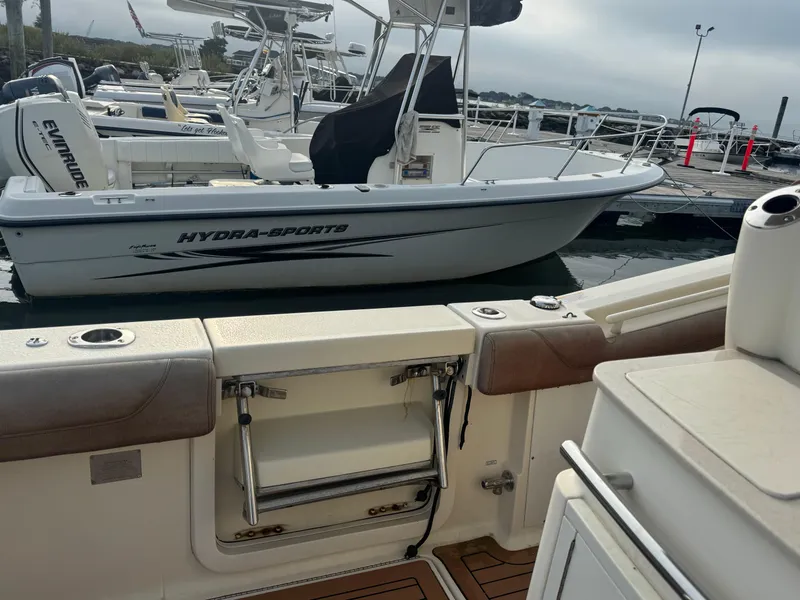 Slide: The Image of 2015 Scout 320 LXF boat docked, featuring a Hydra-Sports vessel in the background. - 11