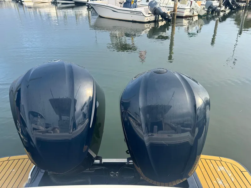 Slide: The Image of 2015 Scout 320 LXF boat engines at a marina dock. - 13