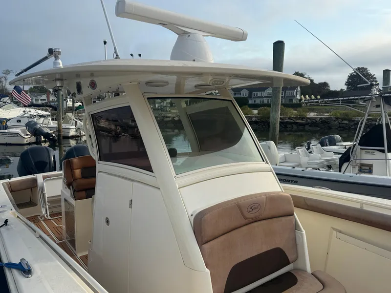 Slide: The Image of 2015 Scout 320 LXF boat docked at marina, featuring sleek design and spacious seating. - 14