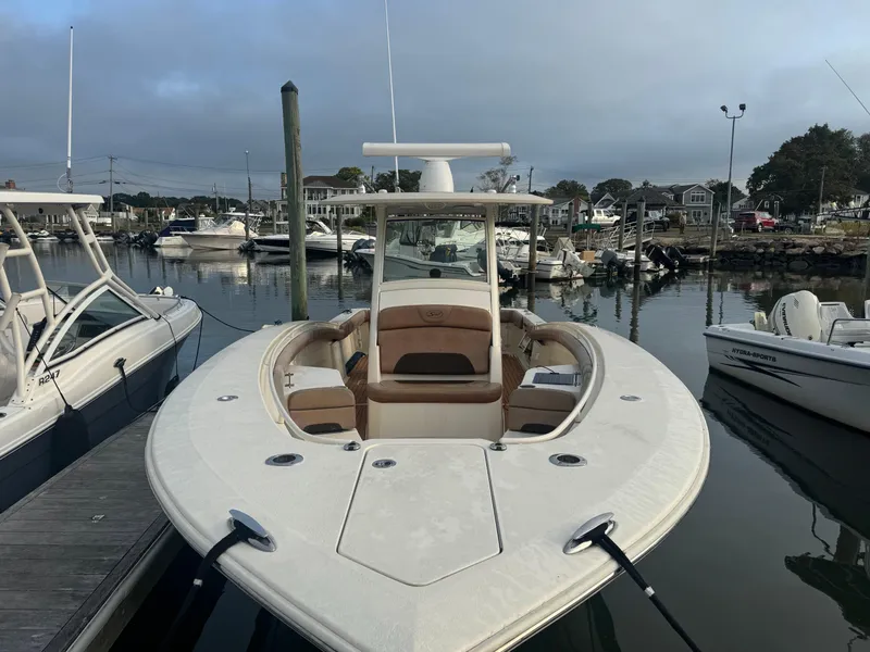 Slide: The Image of 2015 Scout 320 LXF boat docked in a marina, featuring sleek design and spacious seating. - 16