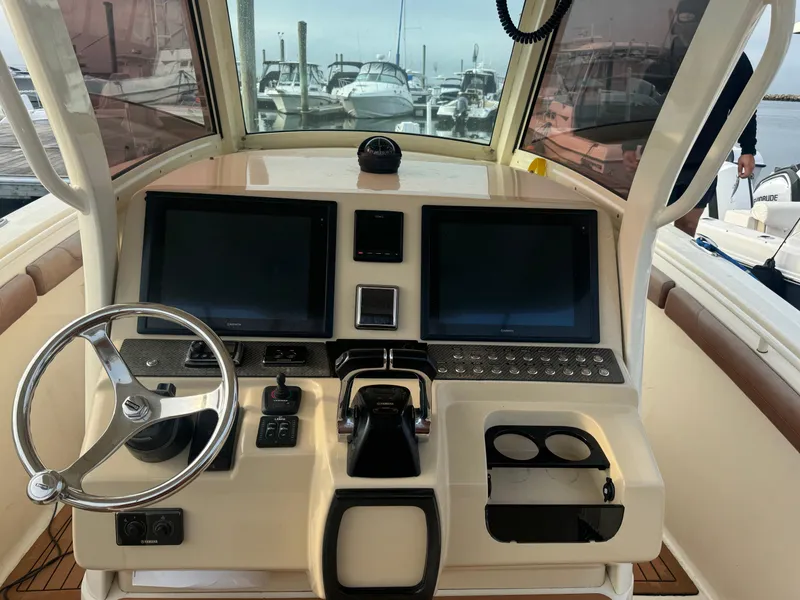 Slide: The Image of 2015 Scout 320 LXF boat dashboard with dual screens and steering wheel. - 4