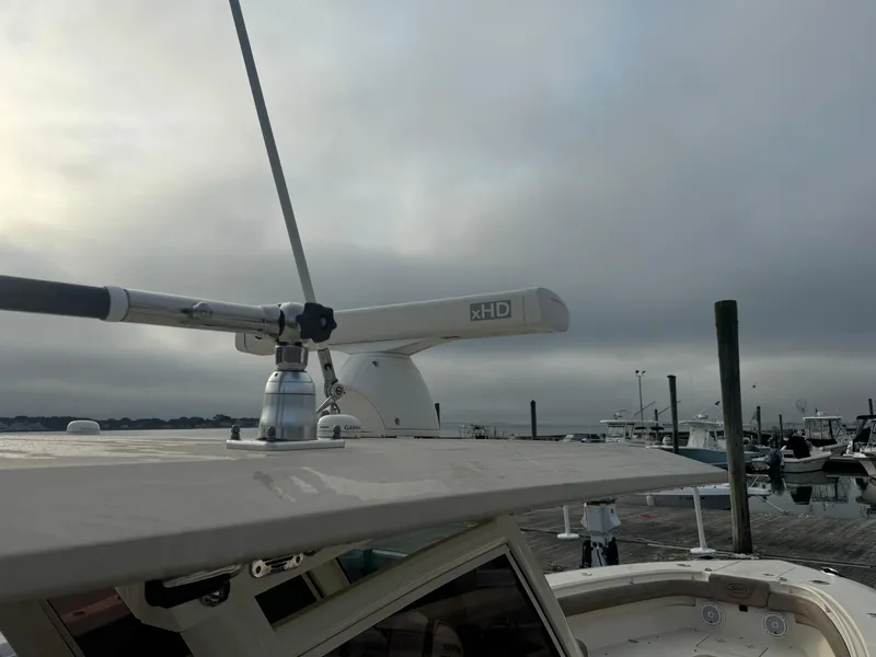 Slide: The Image of 2015 Scout 320 LXF boat with radar equipment at a marina under cloudy skies. - 9