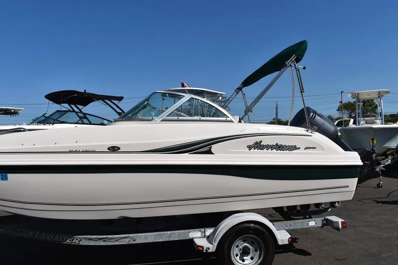 Slide: The Image of 2003 Hurricane SD 187 boat on trailer, side view, clear sky background. - 12