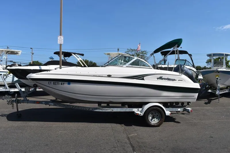 Slide: The Image of 2003 Hurricane SD 187 boat on trailer in parking lot, clear sky background. - 4