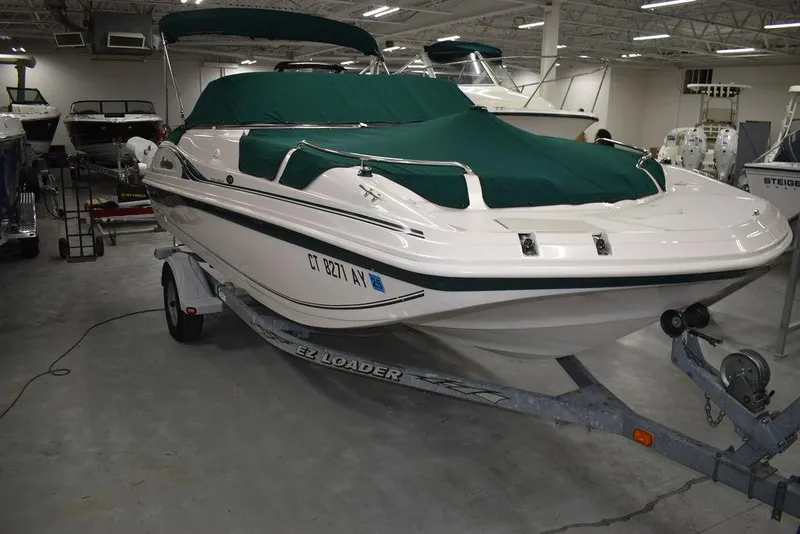 Slide: The Image of 2003 Hurricane SD 187 boat with green cover on trailer in indoor showroom. - 42