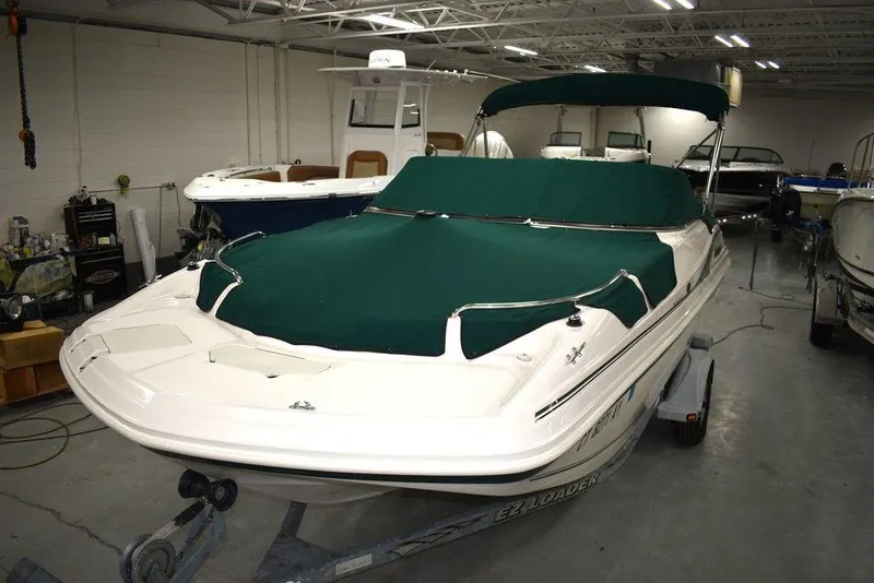 Slide: The Image of 2003 Hurricane SD 187 boat with green covers in a storage facility. - 43