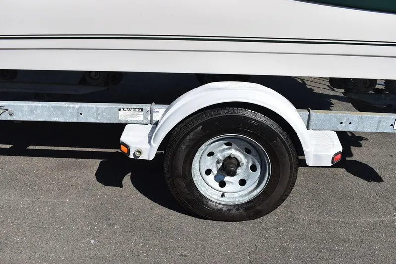 Slide: The Image of Trailer wheel of a 2003 Hurricane SD 187 boat on pavement. - 47