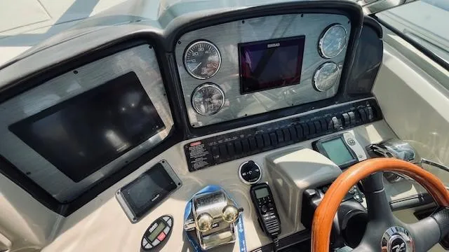 Slide: The Image of Control panel of 2005 Sea Ray 39 Sundancer boat with gauges and steering wheel. - 2