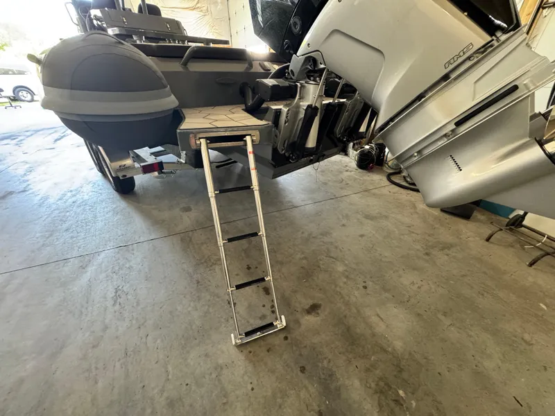 Slide: The Image of 2024 Highfield Sport 900 boat with ladder and outboard motor in a garage. - 10