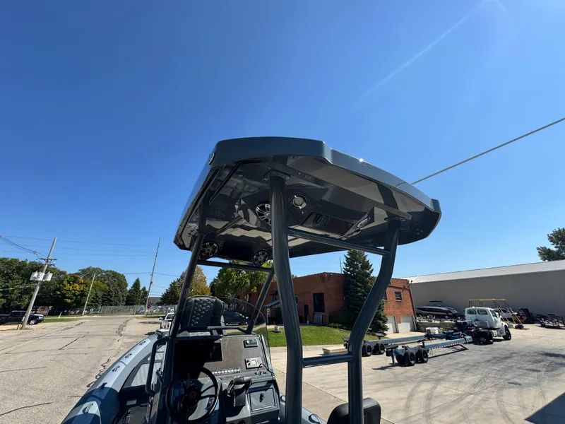 Slide: The Image of 2024 Highfield Sport 900 boat with T-top, parked outdoors under clear blue sky. - 23
