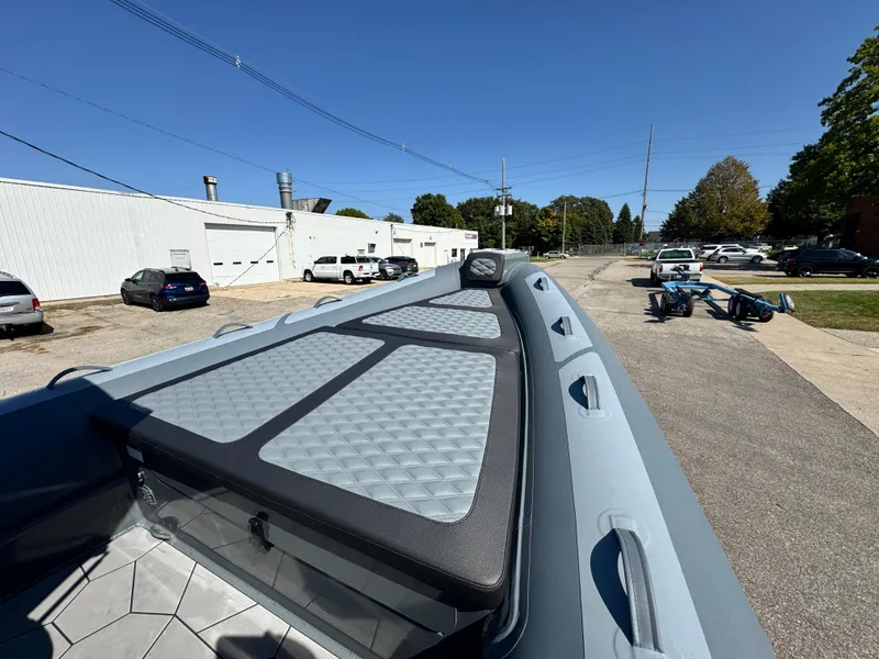 Slide: The Image of 2024 Highfield Sport 900 boat with sleek design and spacious deck in a parking area. - 32