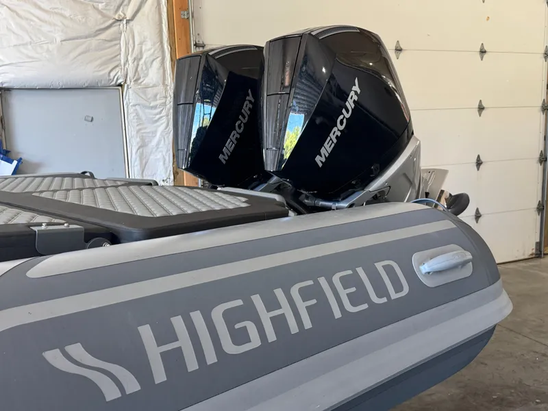 Slide: The Image of 2024 Highfield Sport 900 boat with dual Mercury outboard engines in a garage. - 8