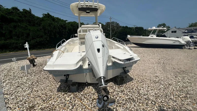 Slide: The Image of 2025 Boston Whaler 220 Dauntless boat displayed on gravel lot. - 2