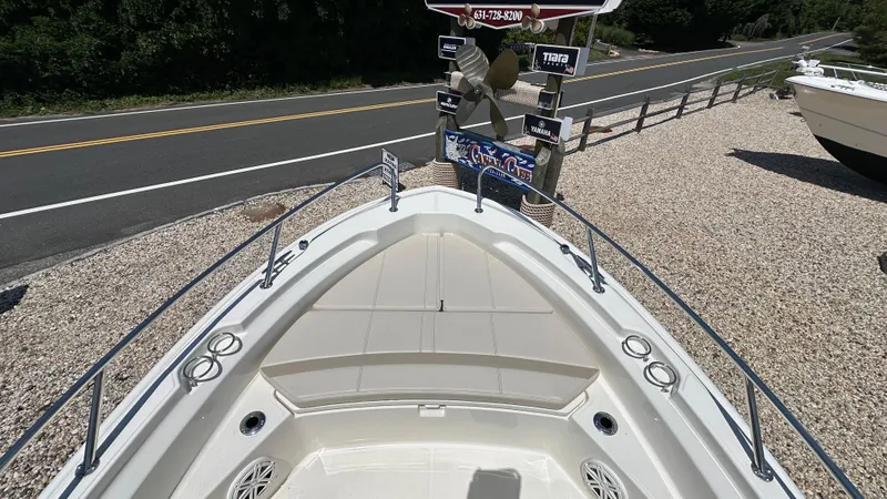 Slide: The Image of 2025 Boston Whaler 220 Dauntless boat bow view near a road. - 21