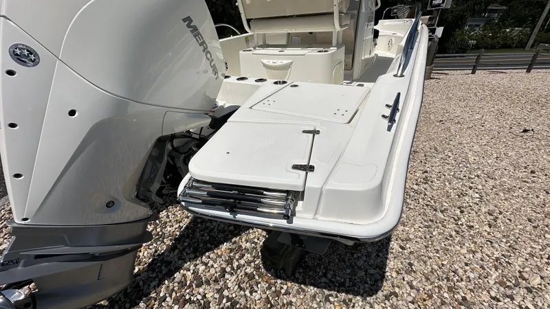 Slide: The Image of 2025 Boston Whaler 220 Dauntless boat with Mercury engine, rear view on gravel. - 3