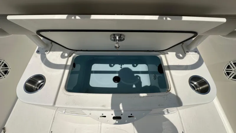 Slide: The Image of 2025 Boston Whaler 220 Dauntless boat interior with storage compartment and cup holders. - 8