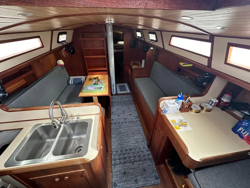 Slide: The Image of Interior of a 1979 Valiant 37 sailboat with cozy seating and kitchen area. - 11