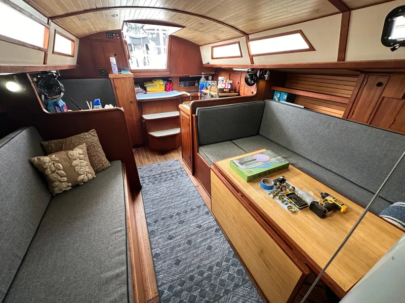 Slide: The Image of Interior of a 1979 Valiant 37 sailboat with cozy seating and wooden finishes. - 14