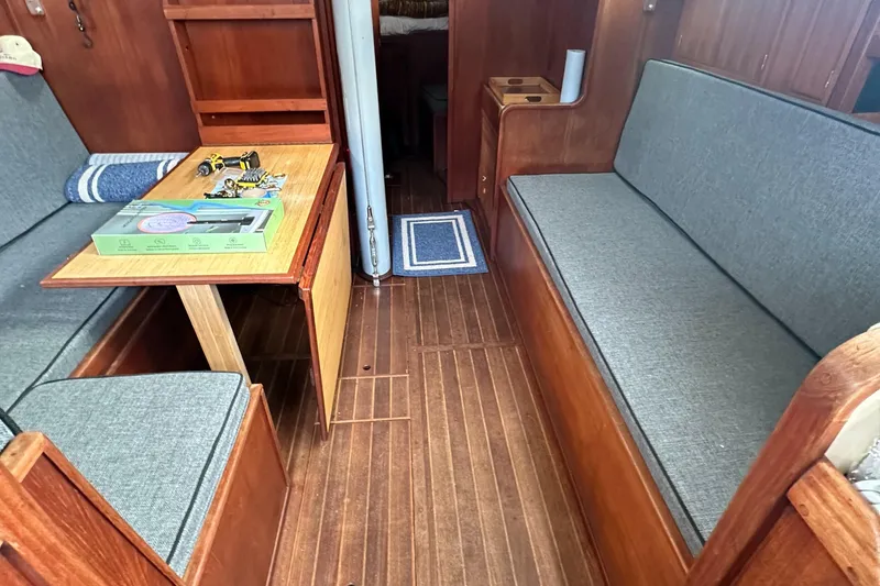 Slide: The Image of 1979 Valiant 37 sailboat interior with wooden flooring and gray cushioned seating. - 15