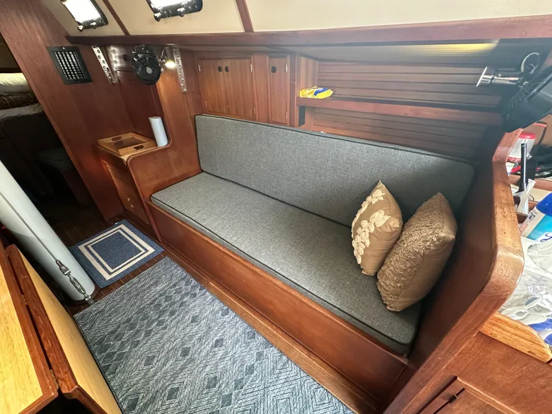 Slide: The Image of 1979 Valiant 37 yacht interior with wooden finish and cushioned seating area. - 16