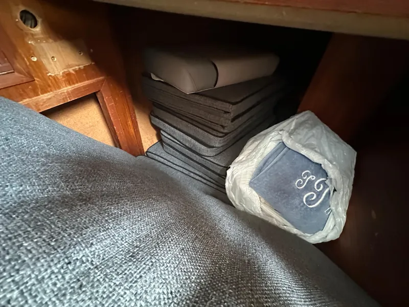 Slide: The Image of Stacked cushions and a monogrammed bag inside a 1979 Valiant 37 boat cabin. - 21