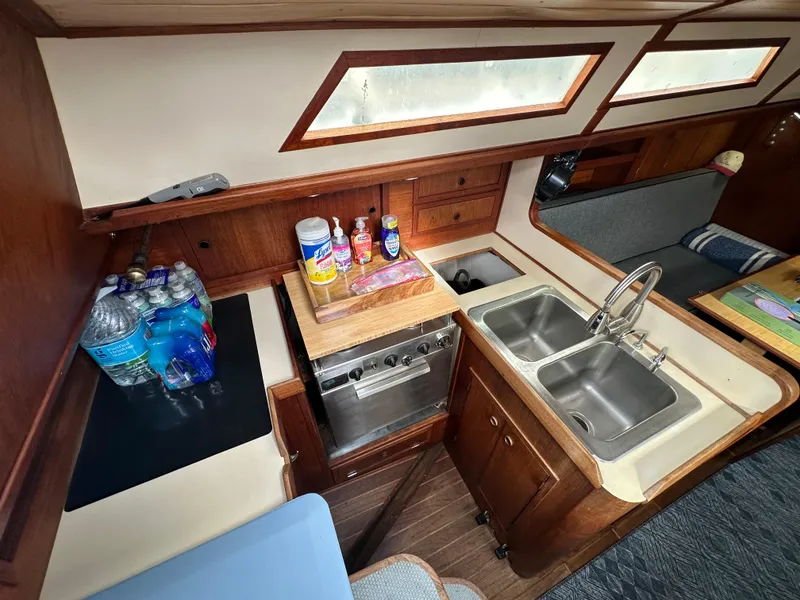 Slide: The Image of 1979 Valiant 37 yacht kitchen with dual sinks, stove, and storage. - 24