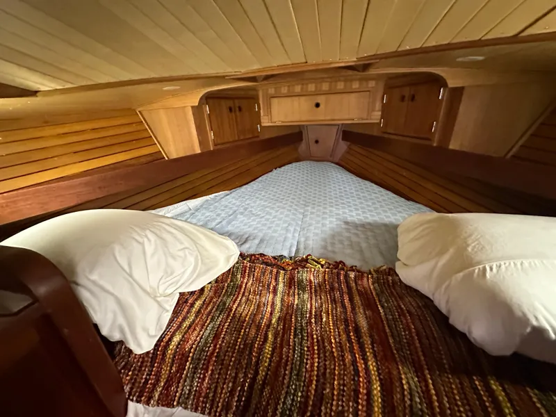 Slide: The Image of Cozy cabin interior of 1979 Valiant 37 sailboat with wooden paneling and bedding. - 32