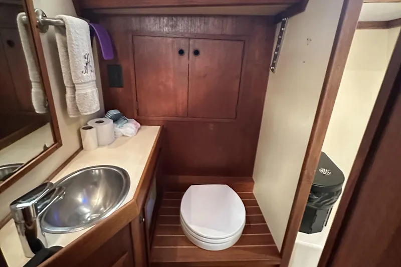 Slide: The Image of 1979 Valiant 37 yacht bathroom with sink, toilet, and wooden cabinetry. - 34