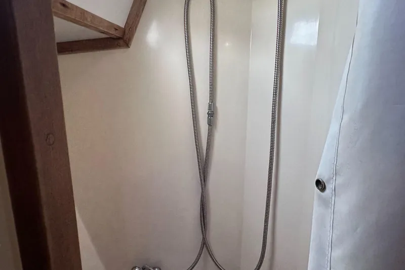 Slide: The Image of 1979 Valiant 37 yacht shower with wooden trim and flexible hose. - 38